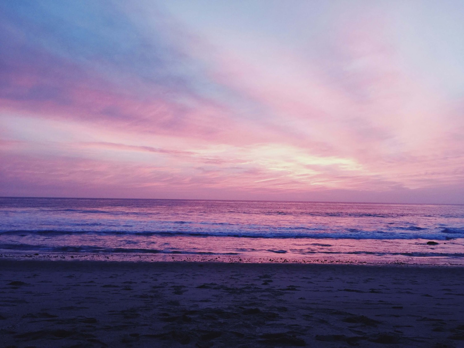 A calm pink and purple sunset over the ocean